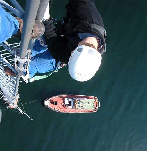 Technician working on an offshore wind station above the sea